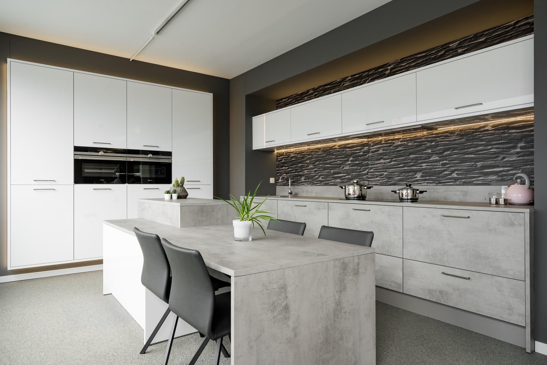 Moderne keuken op maat met betonlook werkblad en witte kasten, ontworpen door Gebroeders Verduyckt in Bocholt